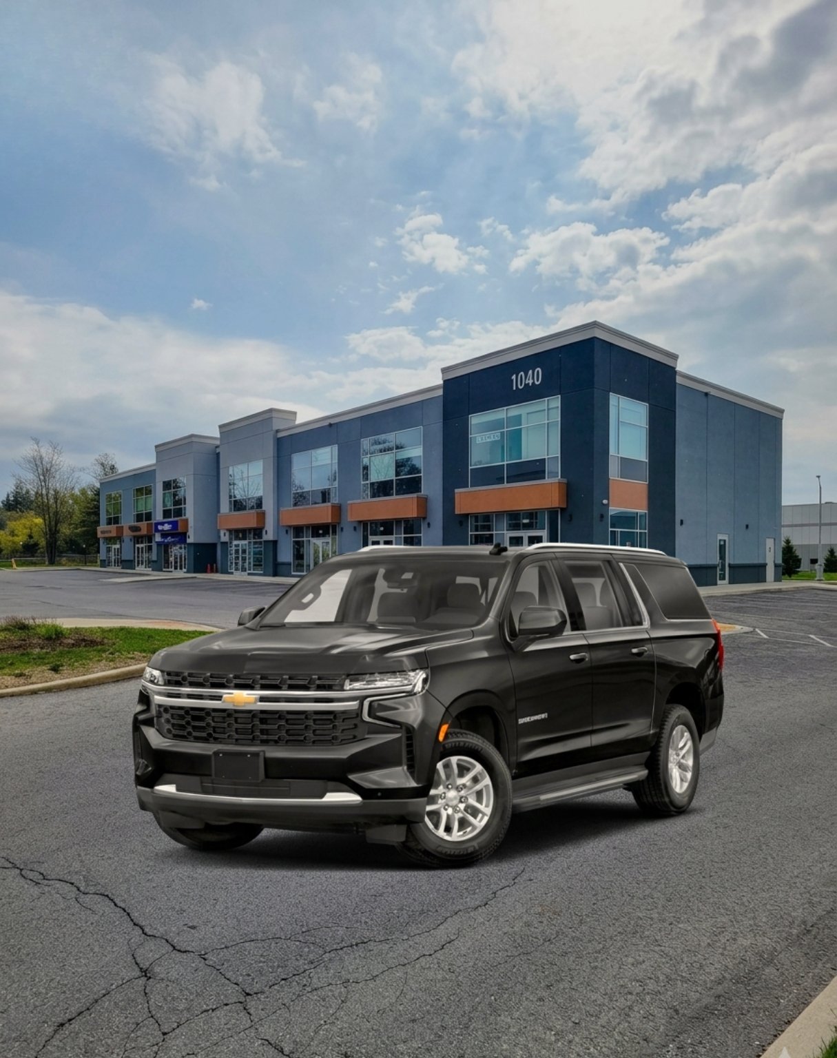 Black Chevrolet SUV parked in an empty lot outside a modern office building with large windows