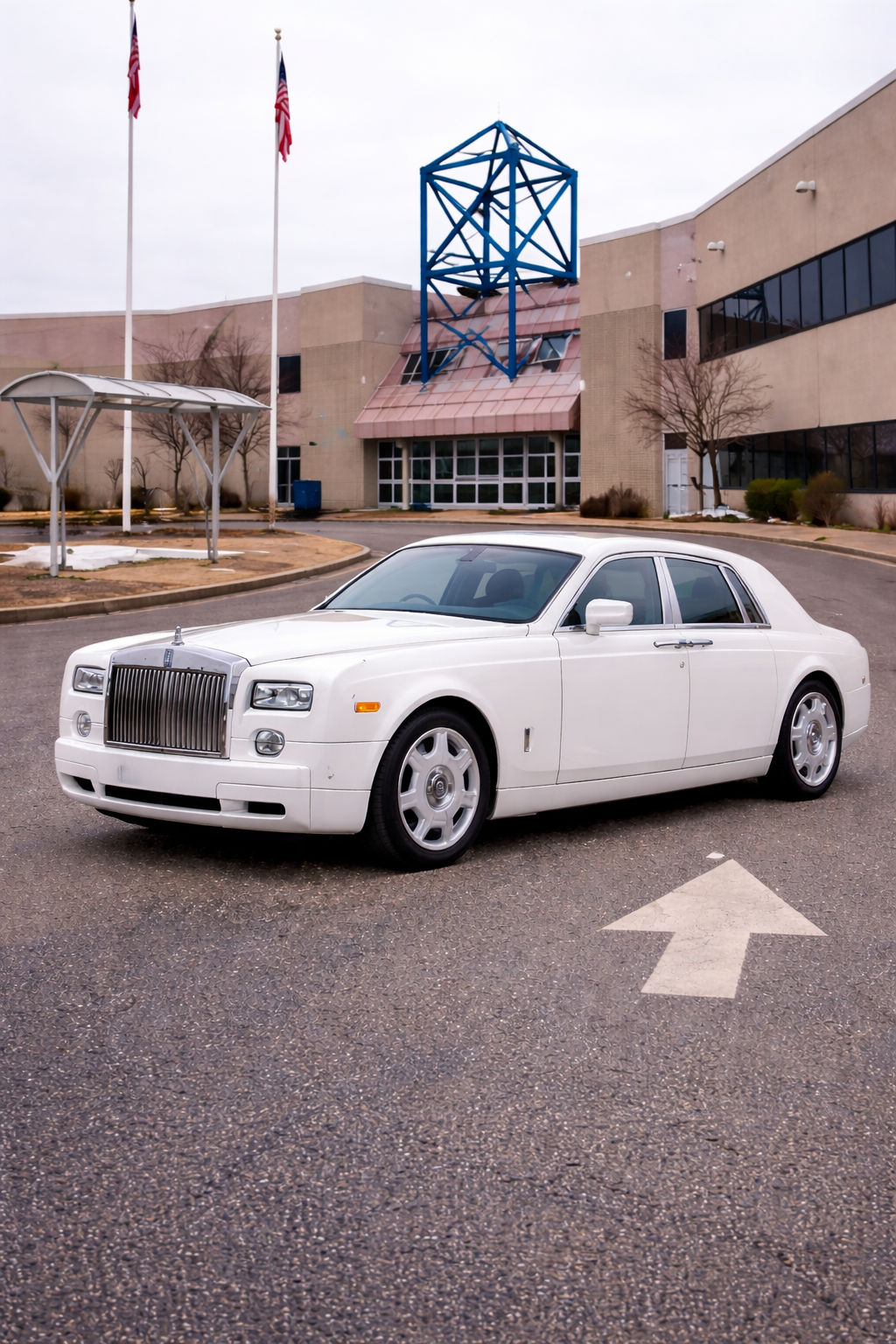 White Rolls Royce luxury car parked outside an airport terminal building for chauffeur service